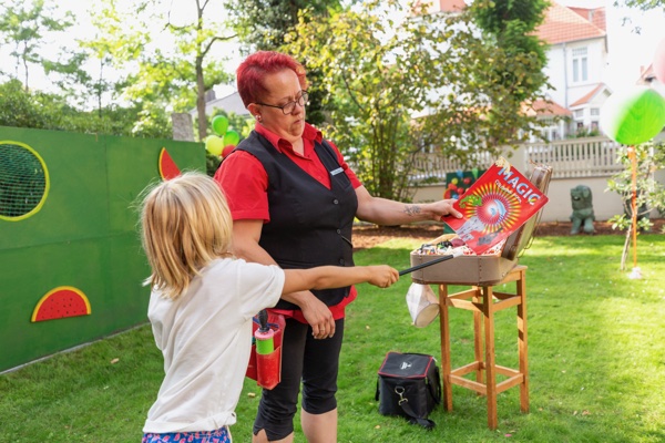 Anika zeigt einem Kind einen Zaubertrick